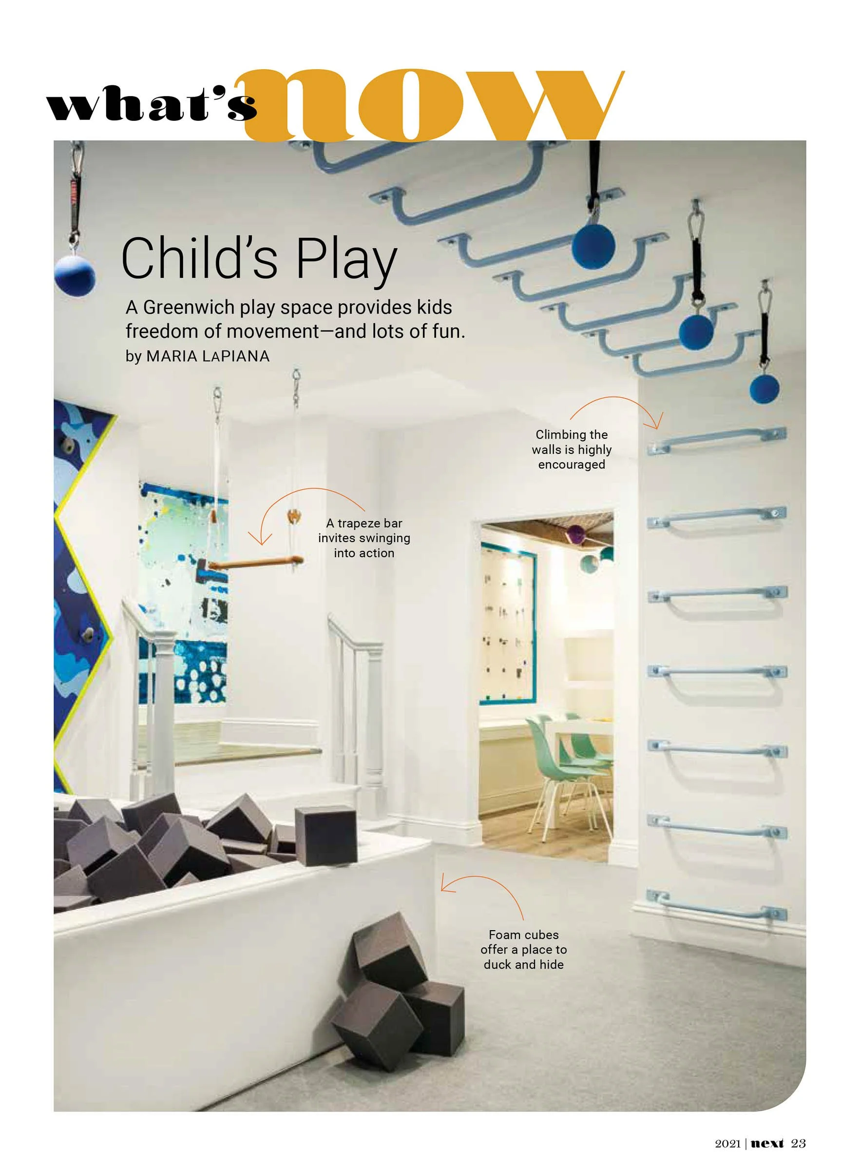 Indoor play space with trapeze bar, climbing wall, and foam cubes for children.