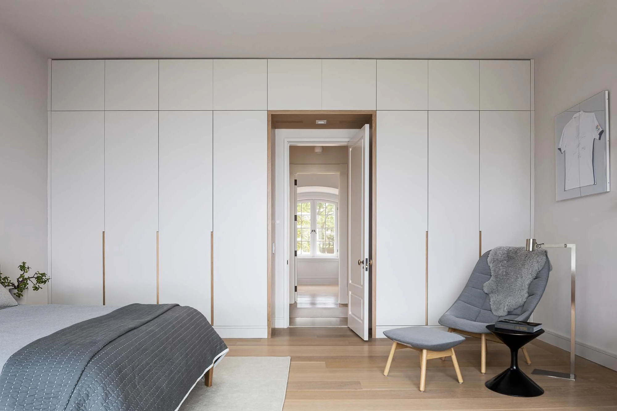 wall to wall and floor to ceiling closet, blue chair and bed