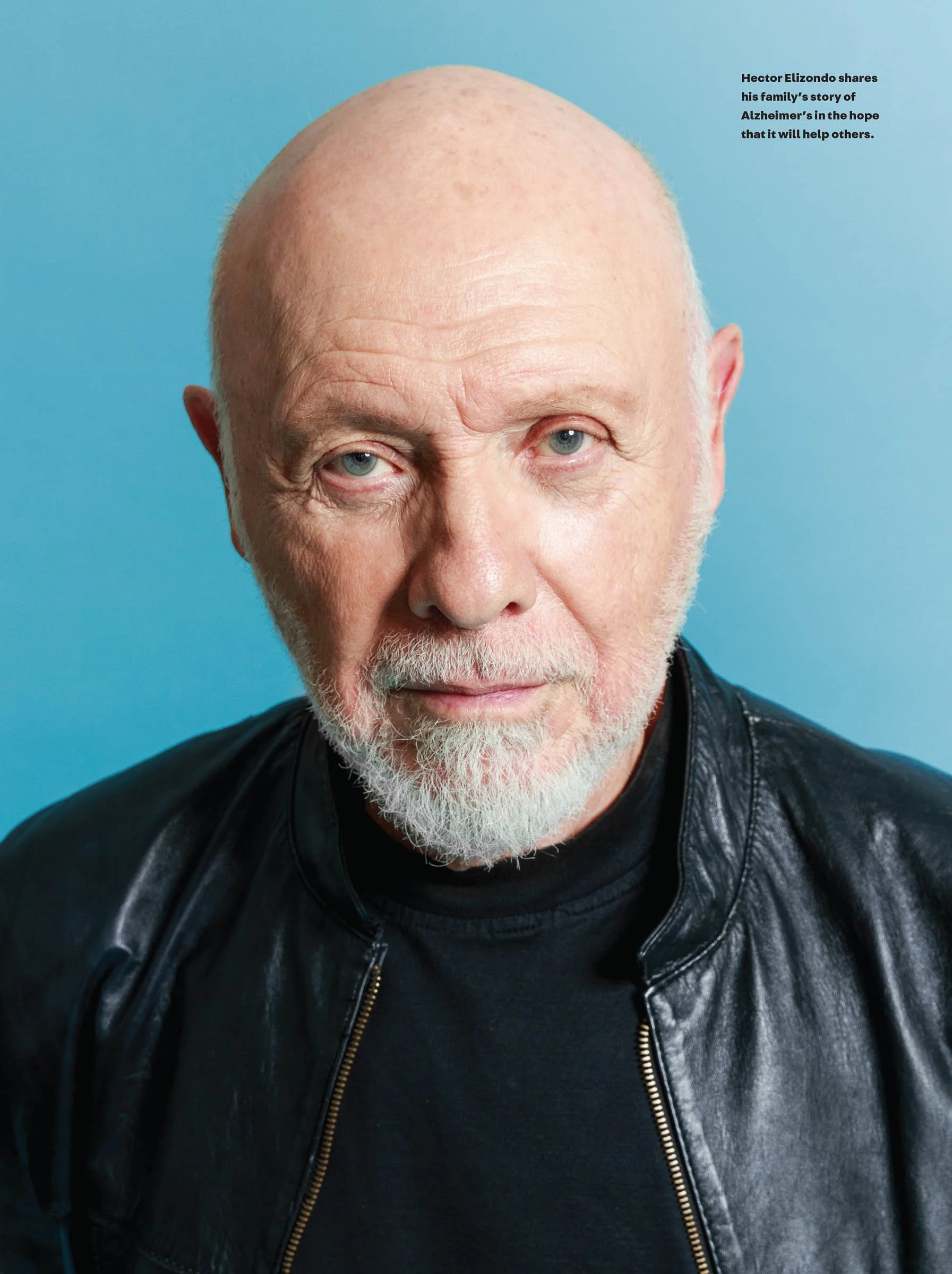 Portrait of an older man with a bald head, wearing a leather jacket and a black shirt, against a blue background. Text on the image mentions a story about Alzheimer's.