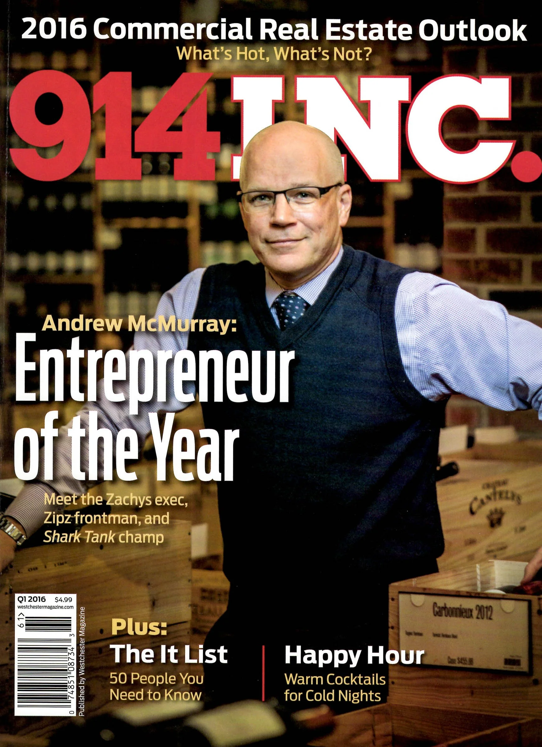 Magazine cover of 914INC. featuring an article about Andrew McMurray, the 'Entrepreneur of the Year', with topics on commercial real estate and popular people. The person is in business attire, standing among wine boxes.