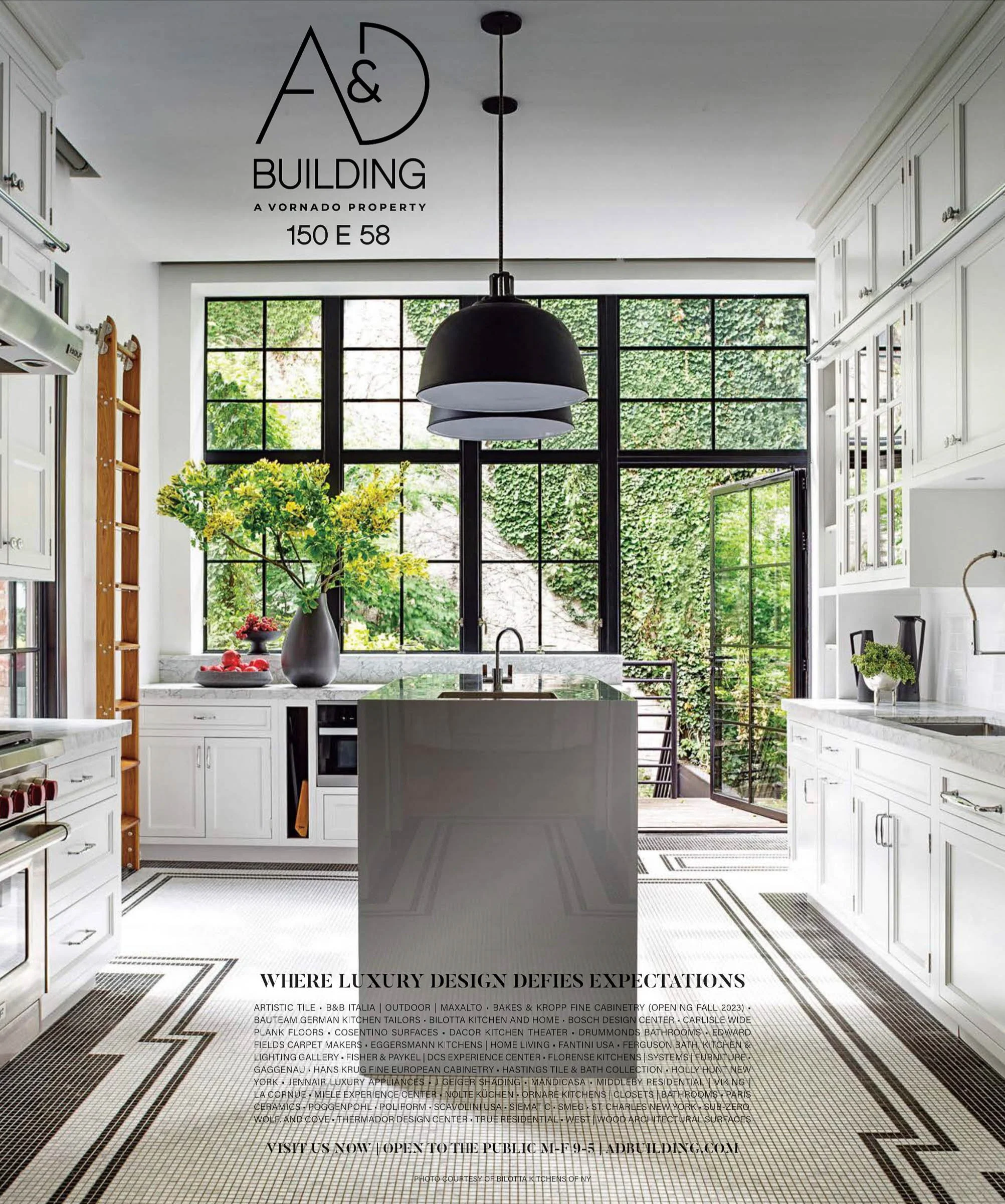 Modern kitchen with white cabinets, large black pendant light, and floor-to-ceiling windows. A kitchen island is in the center, surrounded by greenery outside. Text at the top reads A&D Building, 150 E 58. The bottom text promotes luxury design brand