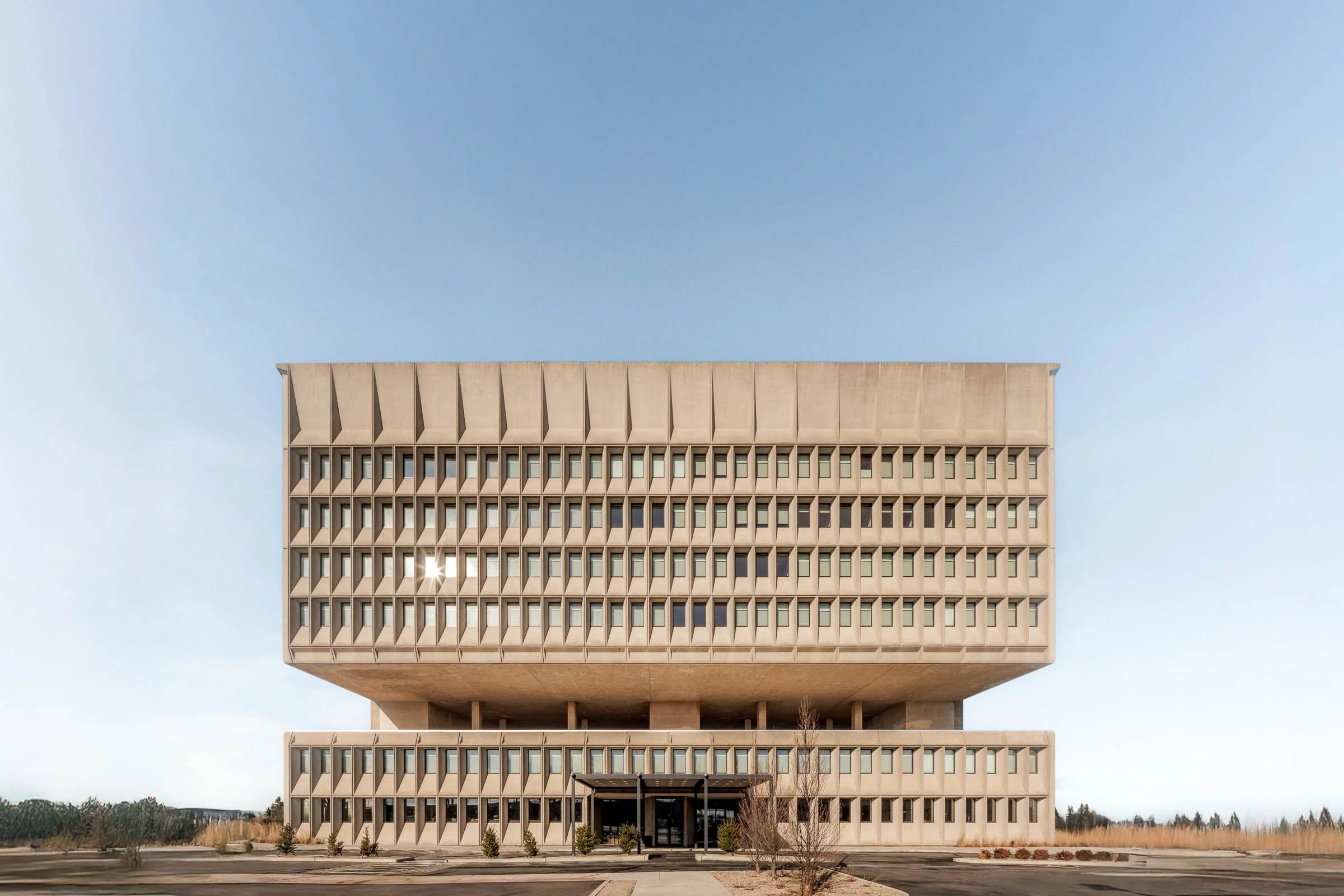 Brutalist-style building with geometric facade against blue sky