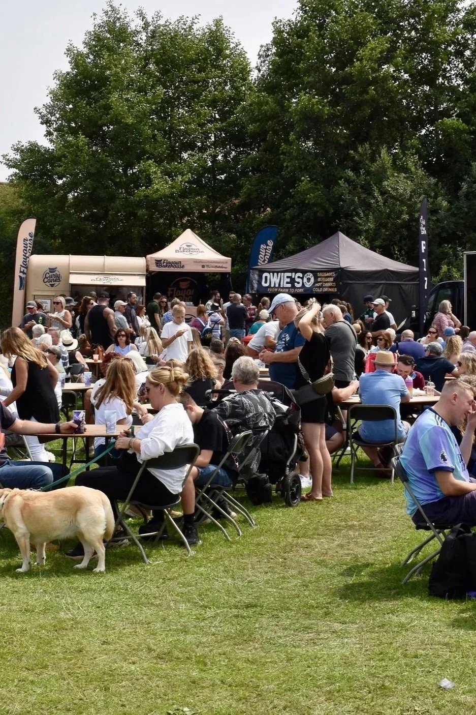 Lots of people sat on chairs, surrounded by food traders.