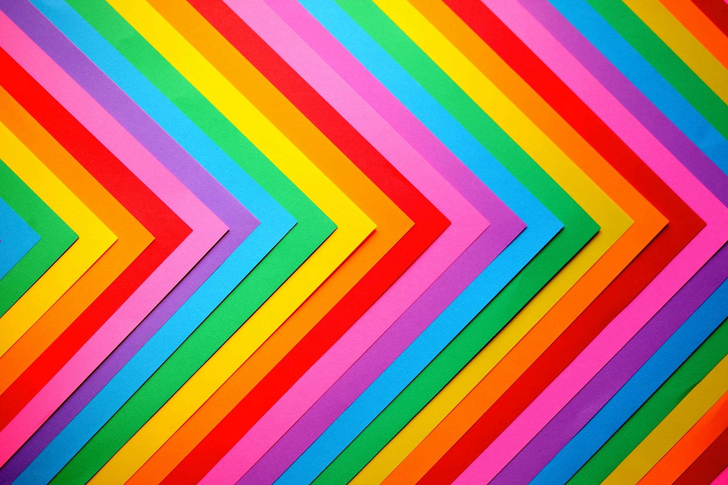 Colorful paper strips arranged in a chevron pattern with pink, yellow, green, blue, purple, orange, and red colors.