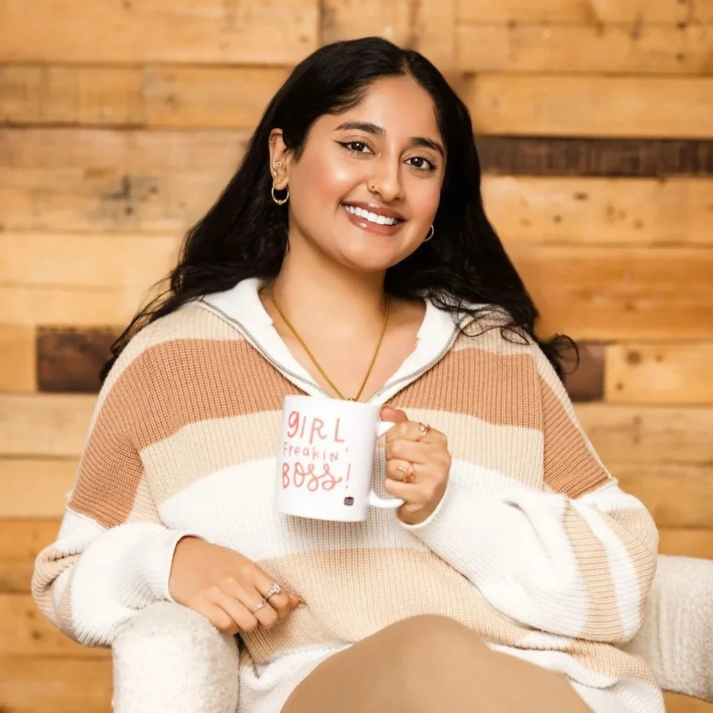 Sanjana Iyer posing for her headshot for the mental health private practice with her "Girl Boss" mug.