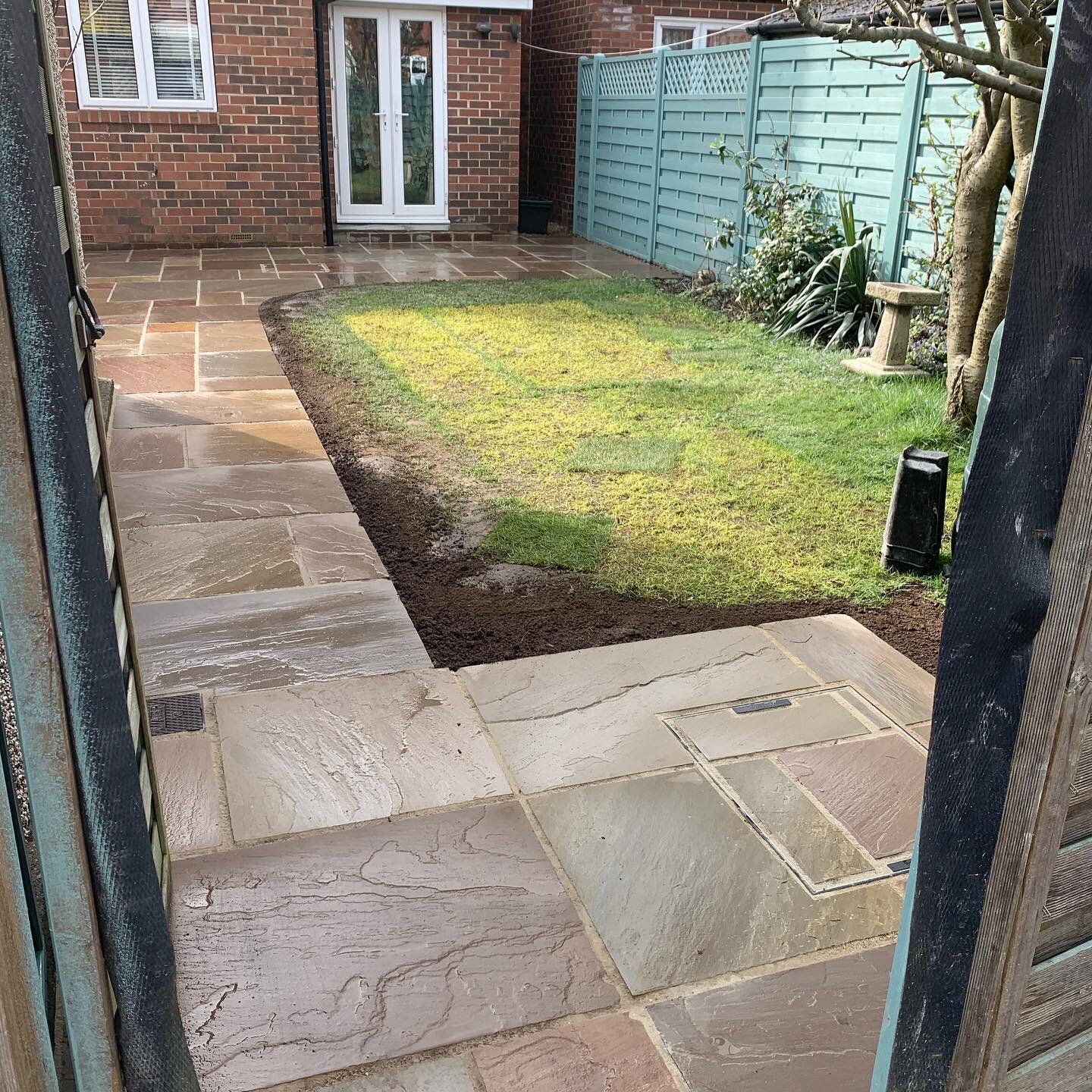 Roseville Road  patio in Raj Green, Indian Stone. With, Seated planter box made from Railway Sleepers.