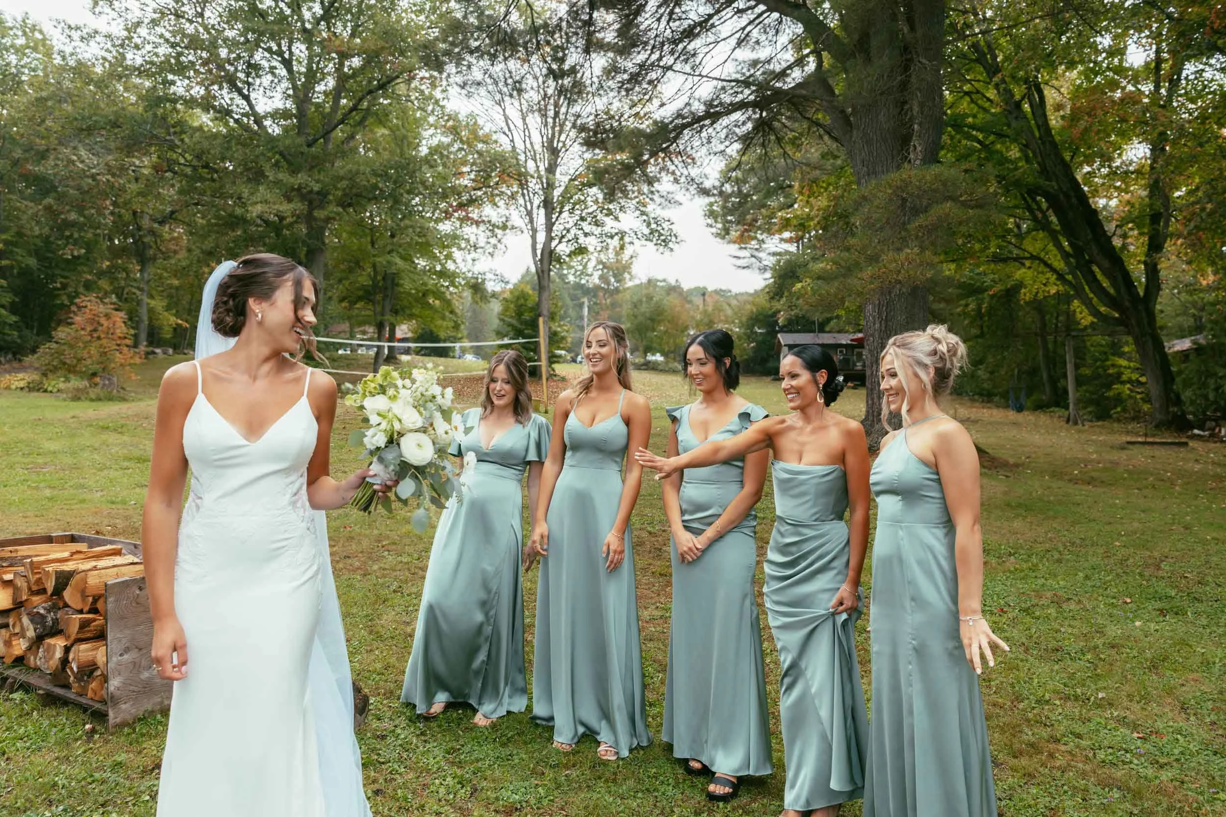 Bride and brides maids having fun at a wedding ceremony in Sudbury,ontario being filmed by a wedding videographer