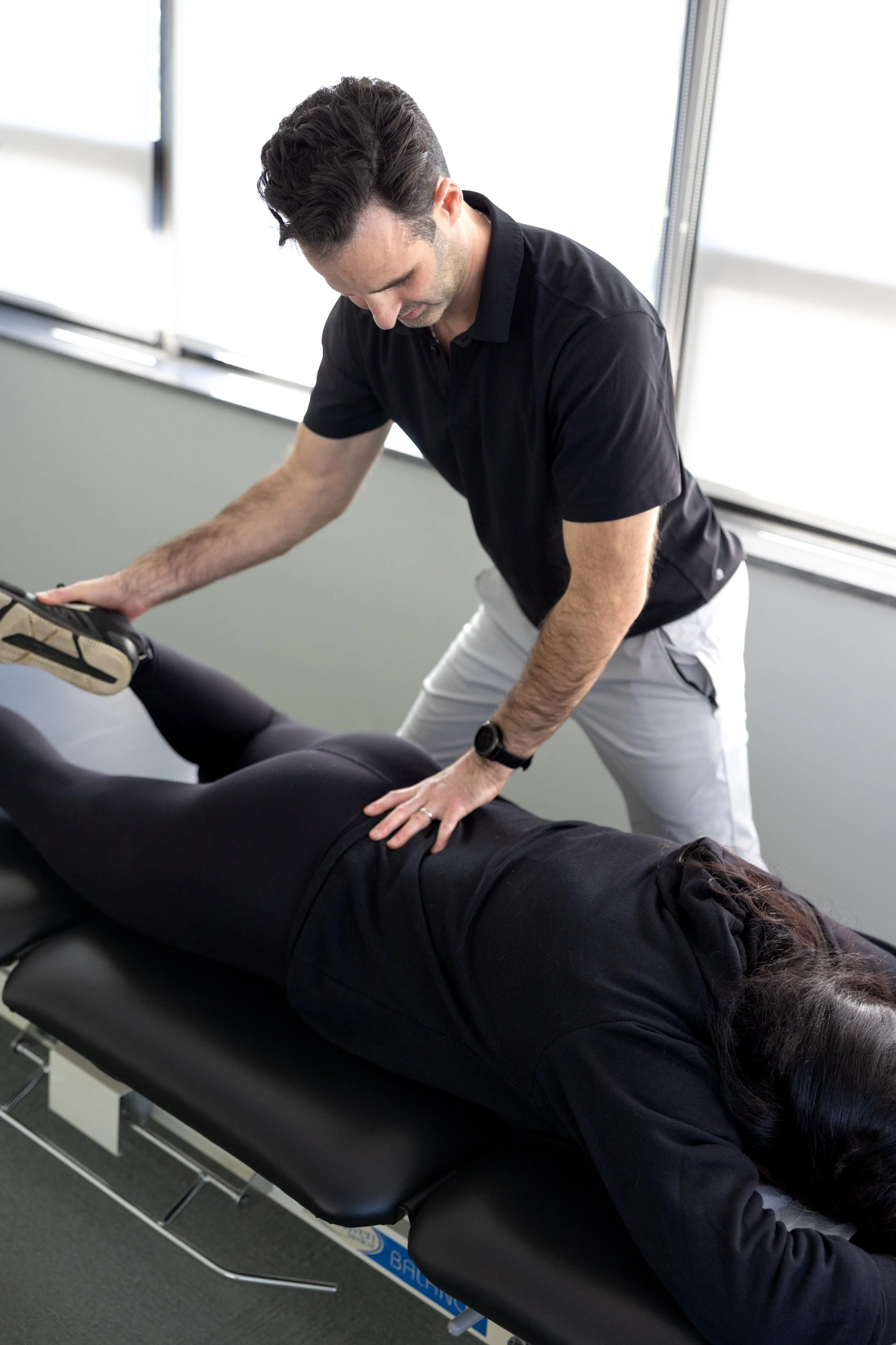 Dr. Bryan Abrams providing hands-on chiropractic treatment to a patient at Healing Motion in Bloomfield Hills, Michigan.