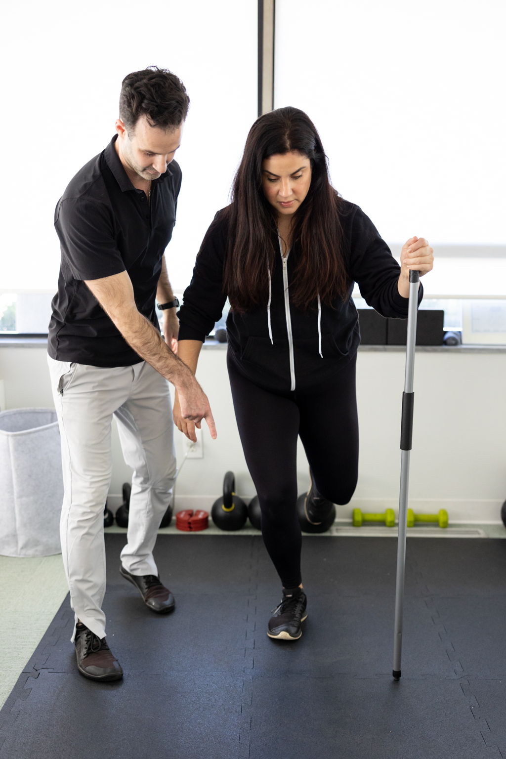 Dr. Bryan Abrams guiding a patient through a balance and rehabilitation exercise at Healing Motion in Bloomfield Hills, Michigan.