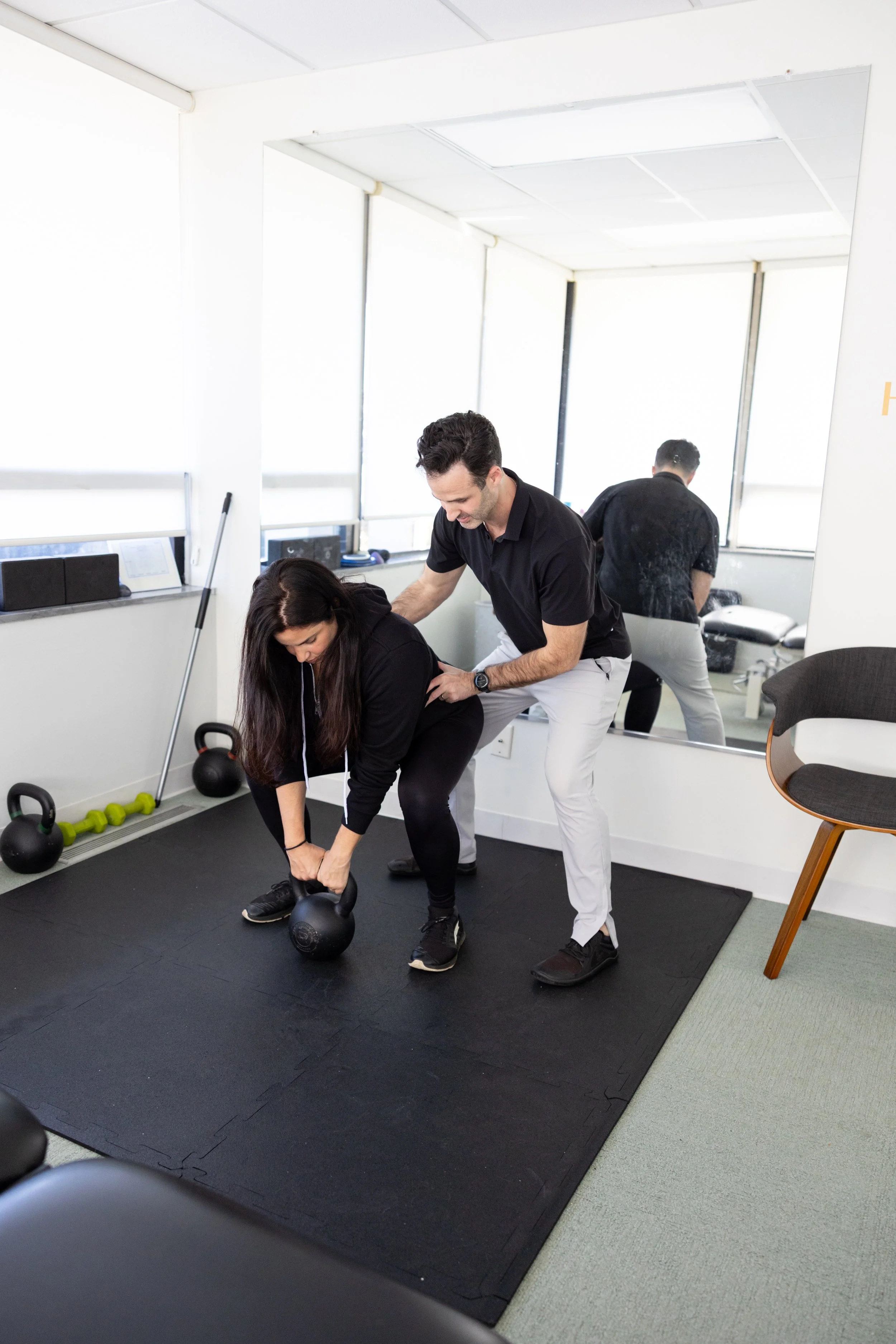 Dr. Bryan Abrams guiding a patient through a functional rehabilitation exercise at Healing Motion chiropractic clinic.