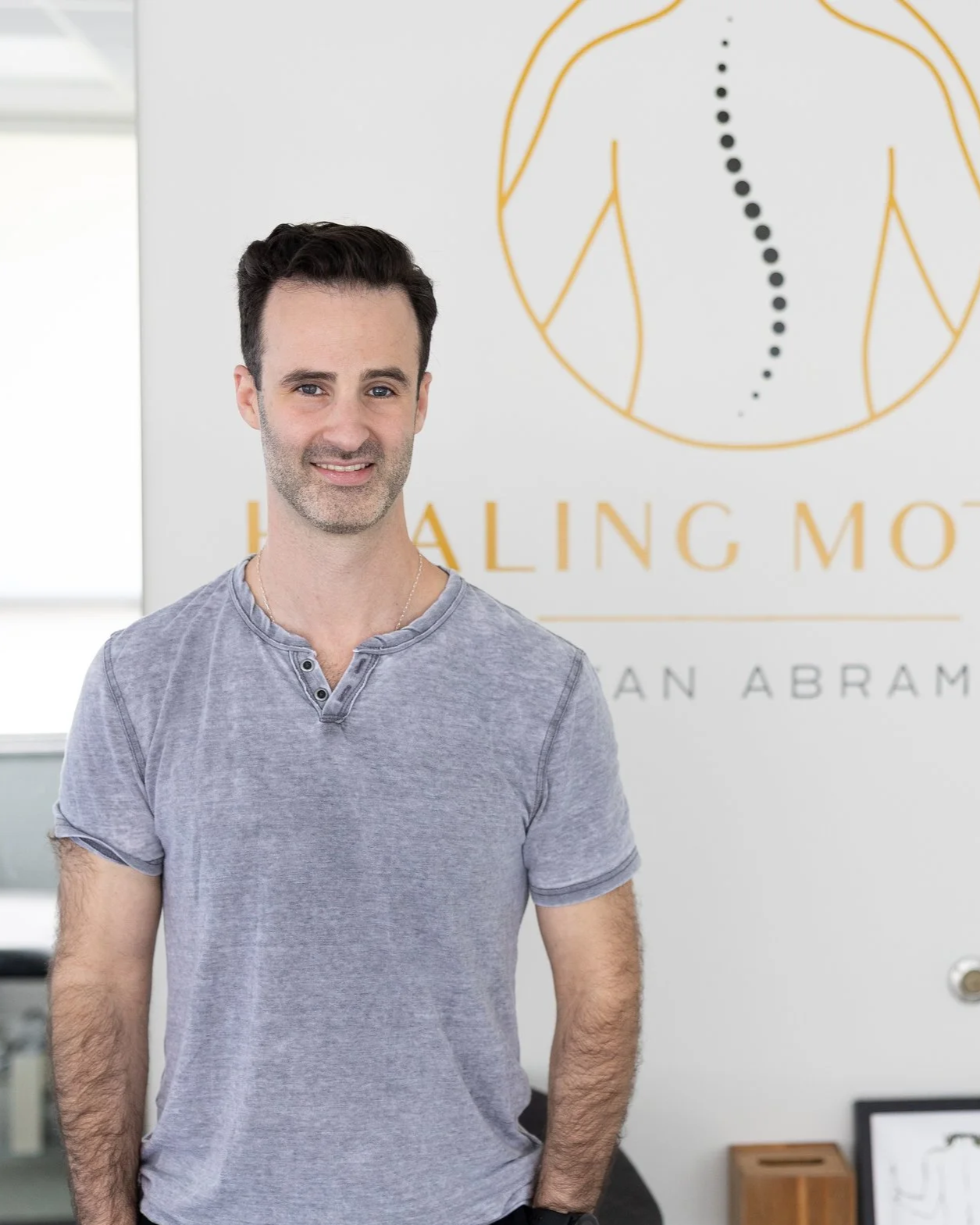Dr. Bryan Abrams, chiropractor and founder of Healing Motion, standing in his Bloomfield Hills, Michigan office.