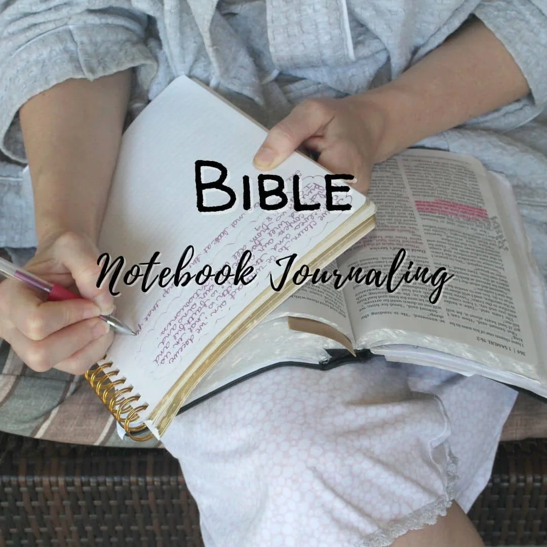 woman sitting with an open Bible as she Bible notebook journals