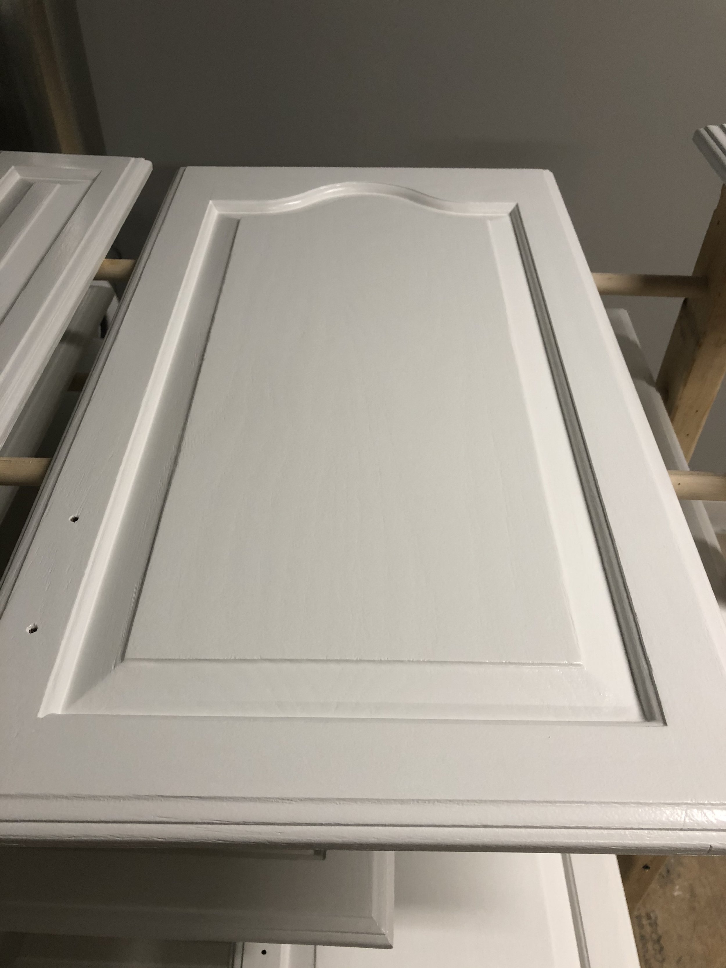 White cabinet door with decorative molding lying on a work table