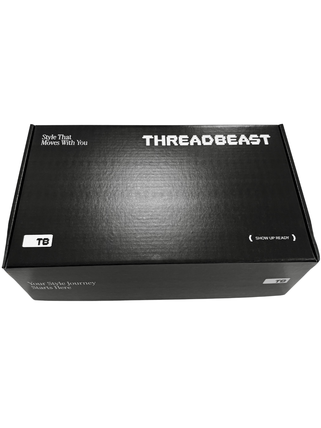Black box with white text reading 'Style That Moves With You' and 'Your Style Journey Starts Here', with 'THREADBEAST' logo in the center, and labels 'TB' and 'SHOW UP READY' on the sides.