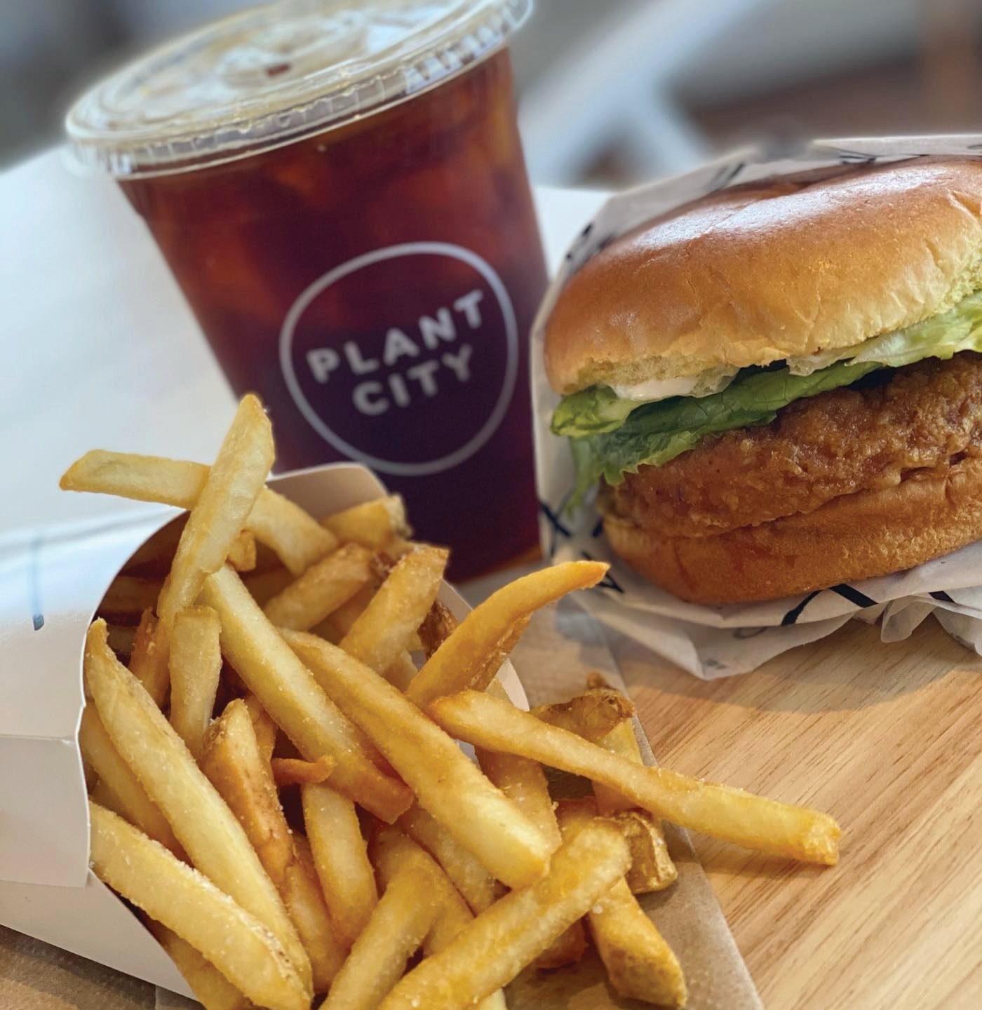 Buffalo chik'n sandwich with crispy fries and iced coffee.