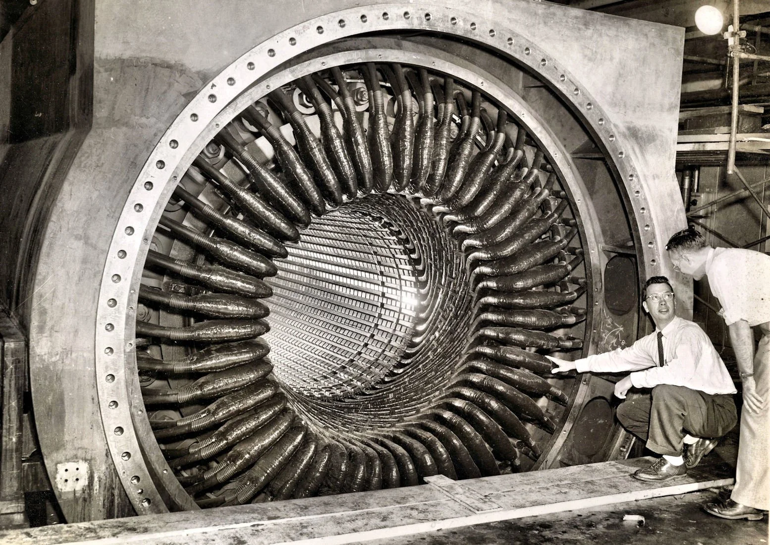 Don Albright in front of a large water-cooled stator with the rotor pulled.