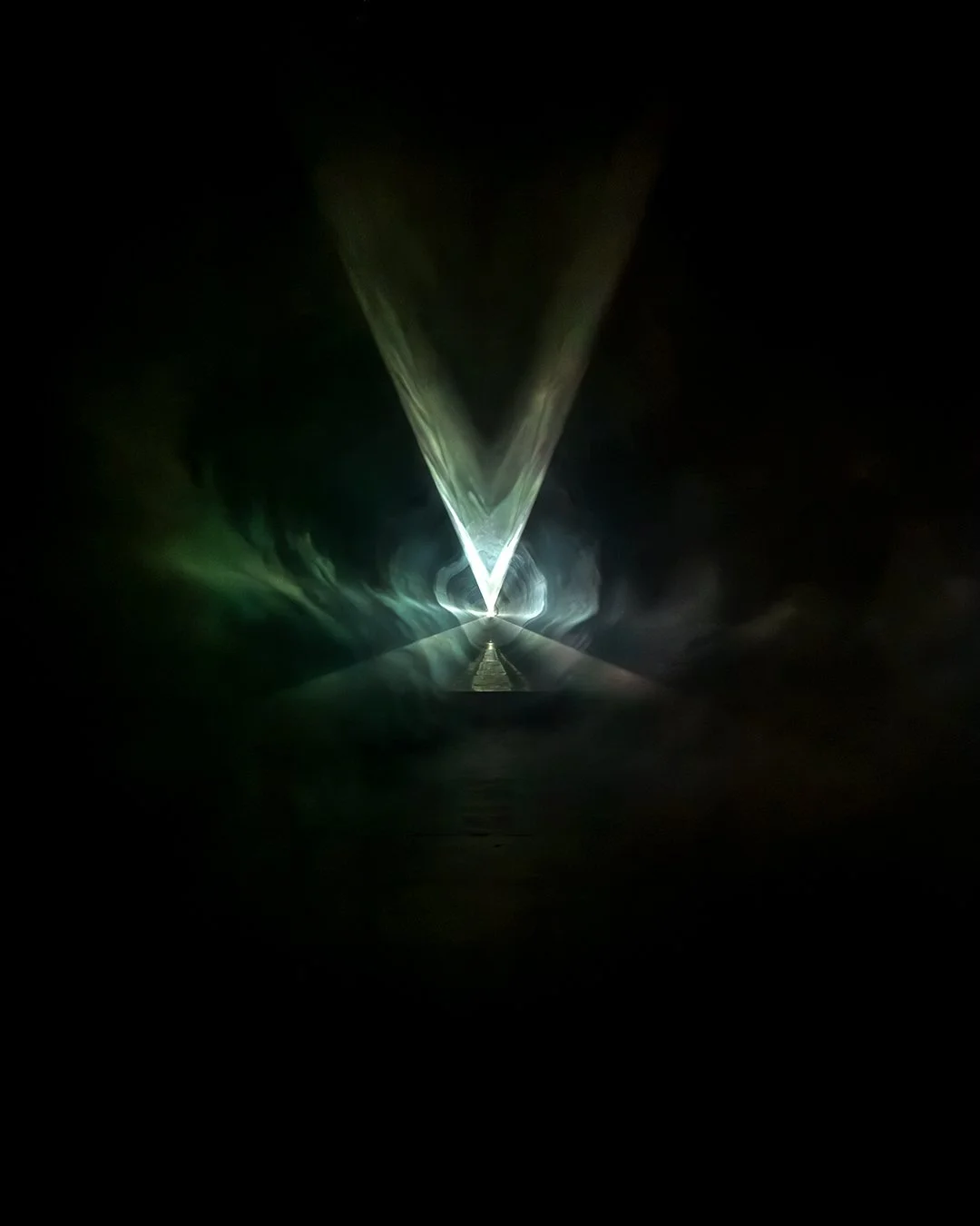 Laser beam forming a V shape in a dark tunnel