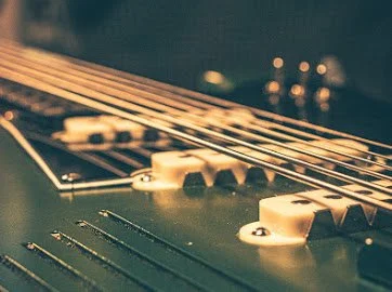 Close-up of an electric guitar's strings and pickups.