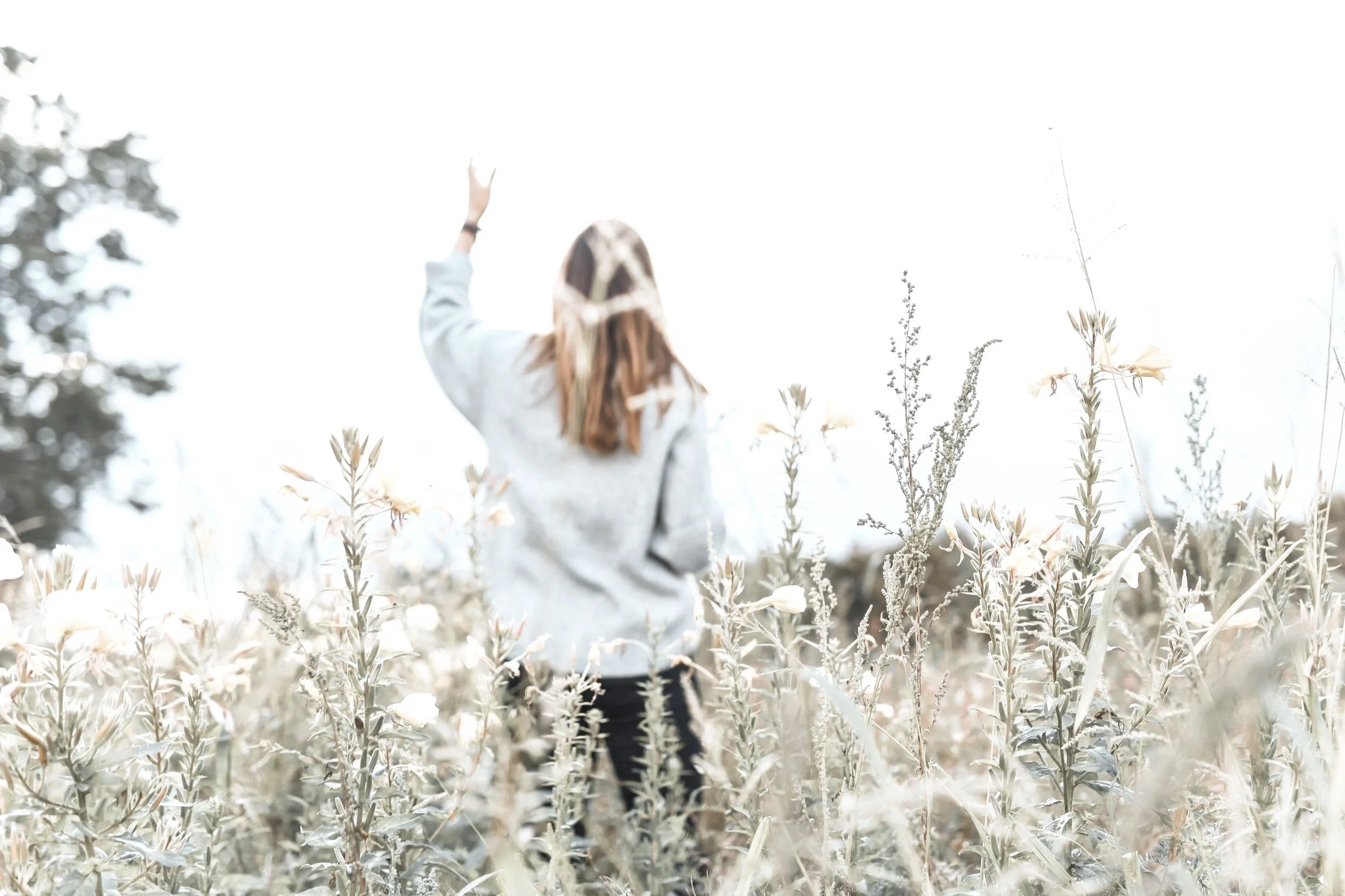 Woman Relaxing in field, breathing, practicing mindfulness, meditating or reflecting.