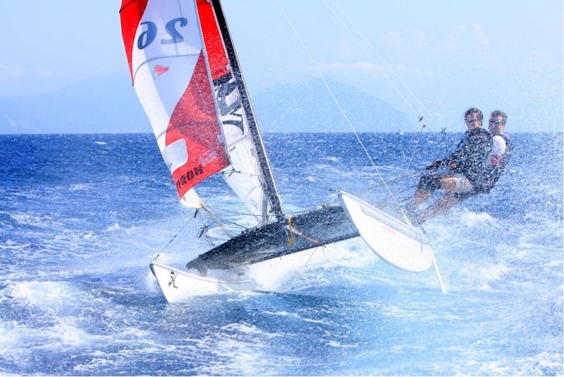two men on a a small sailboat on blue waters