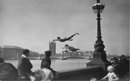 black & white picture of people jumping into a river