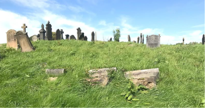 old cemetery with grass and blue sky