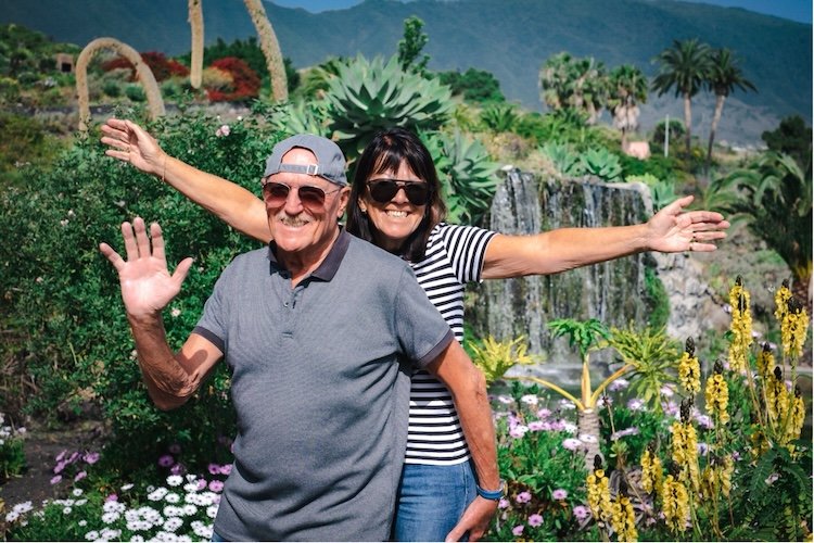 happy couple on holiday in a garden with a waterfall in the background