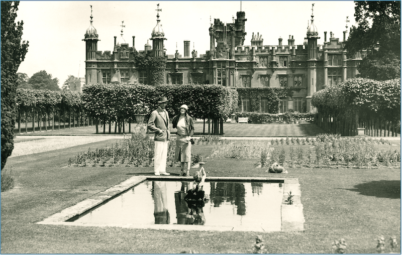 vintage photo of a couple in a garden by a castle-like building