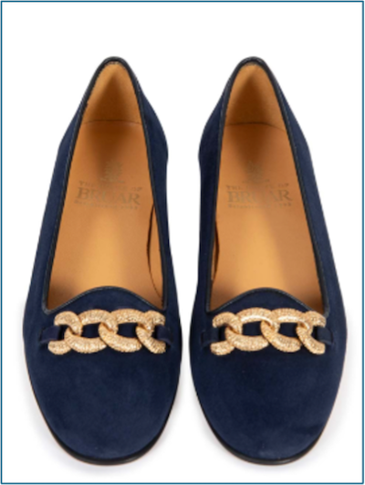 A pair of suede shoes with a gold chain across the front