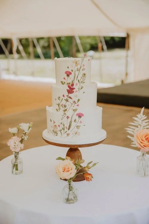 cake table with a wild flower wedding cake