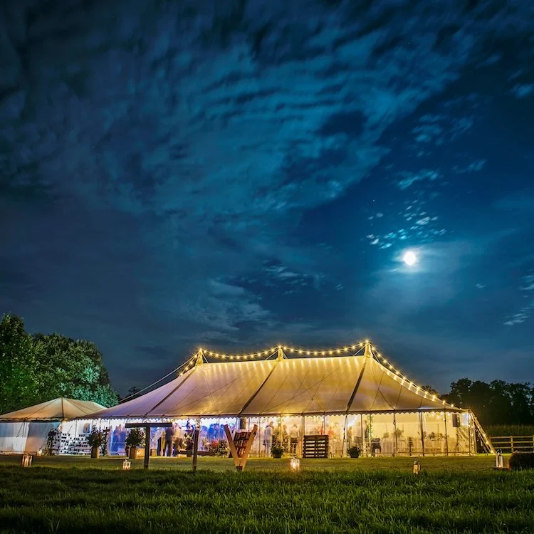 South West Marquee's pole tent lit up at night time in the South West countryside