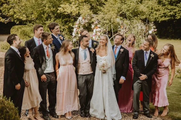 happy wedding guests posing for a photo in the garden