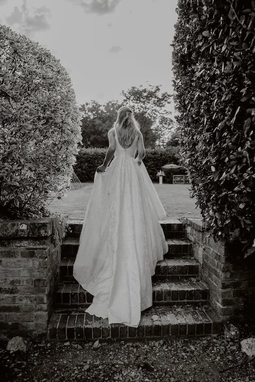 a bride walking up the steps in her garden