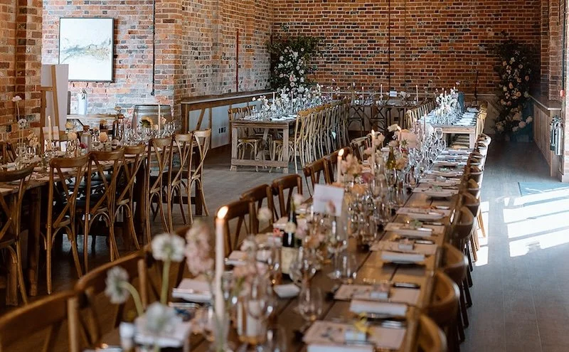 Long wooden tables at a rustic wedding venue in Wiltshire