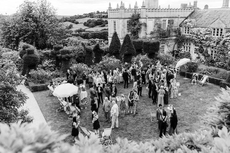 a group of wedding guests mingling in the grounds of euridge manor