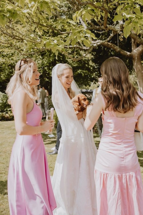 bridesmaids and brides holding a cute sausage dog