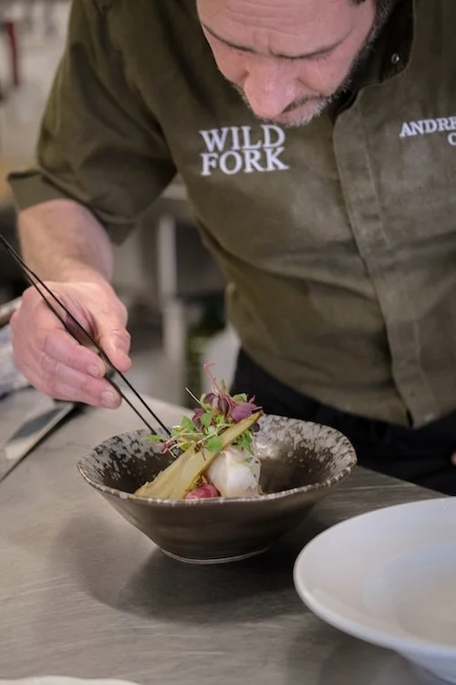 Image of a chef using tweezers to plate a summer wedding dish