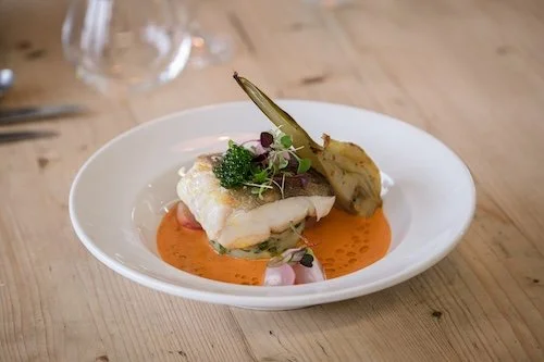 A colourful plate of a roasted fish dish for a summer wedding