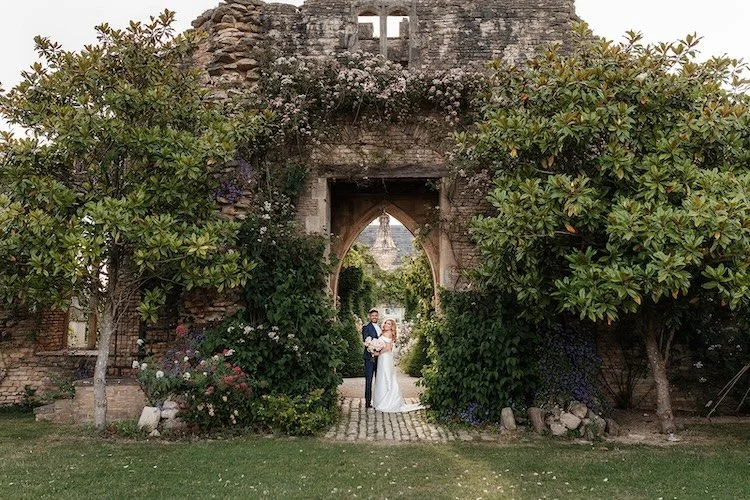 a couple under a chandelier arch at euridge manor