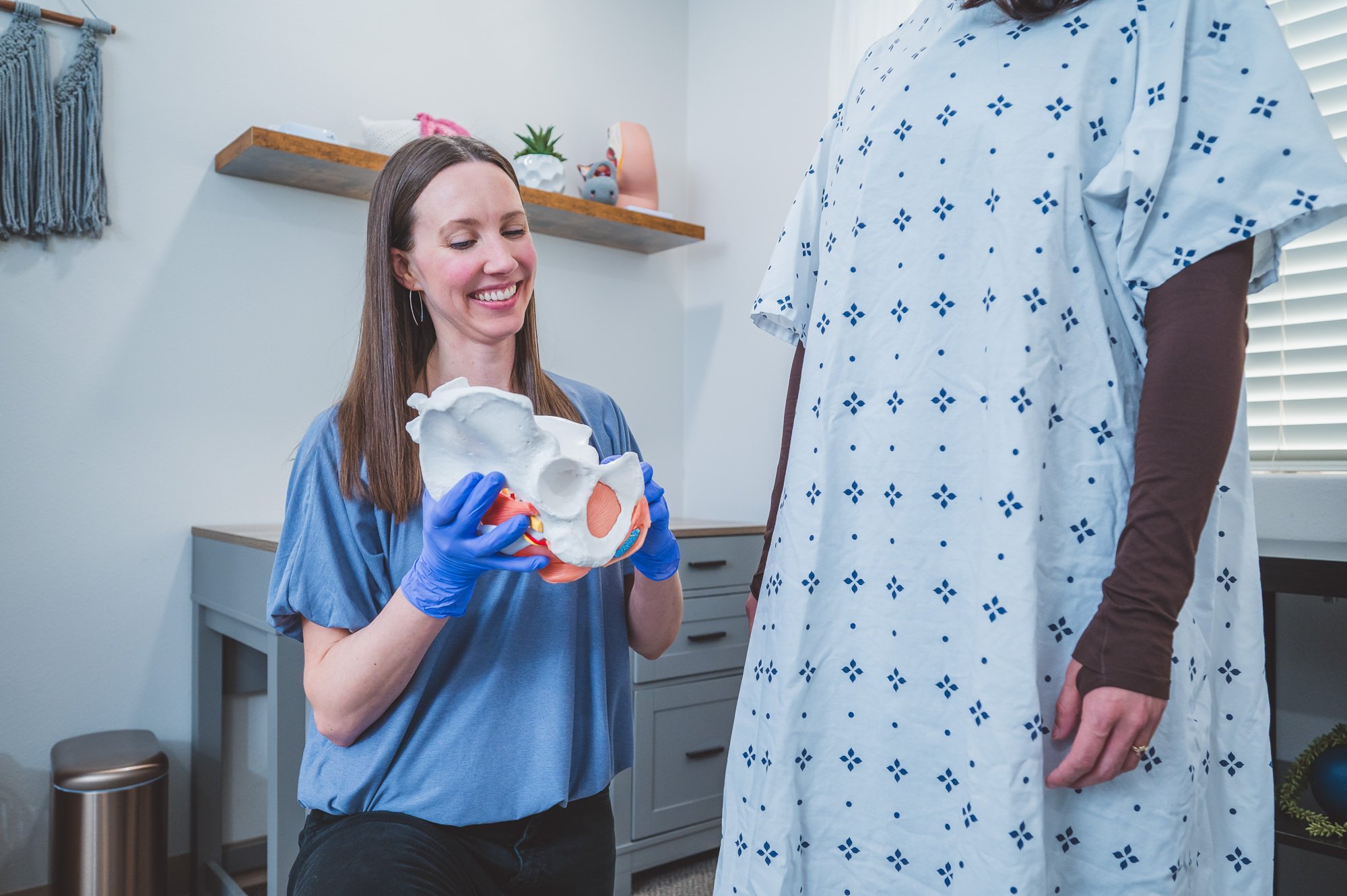 pelvic therapist using a pelvic model to demonstrate use of a pessary