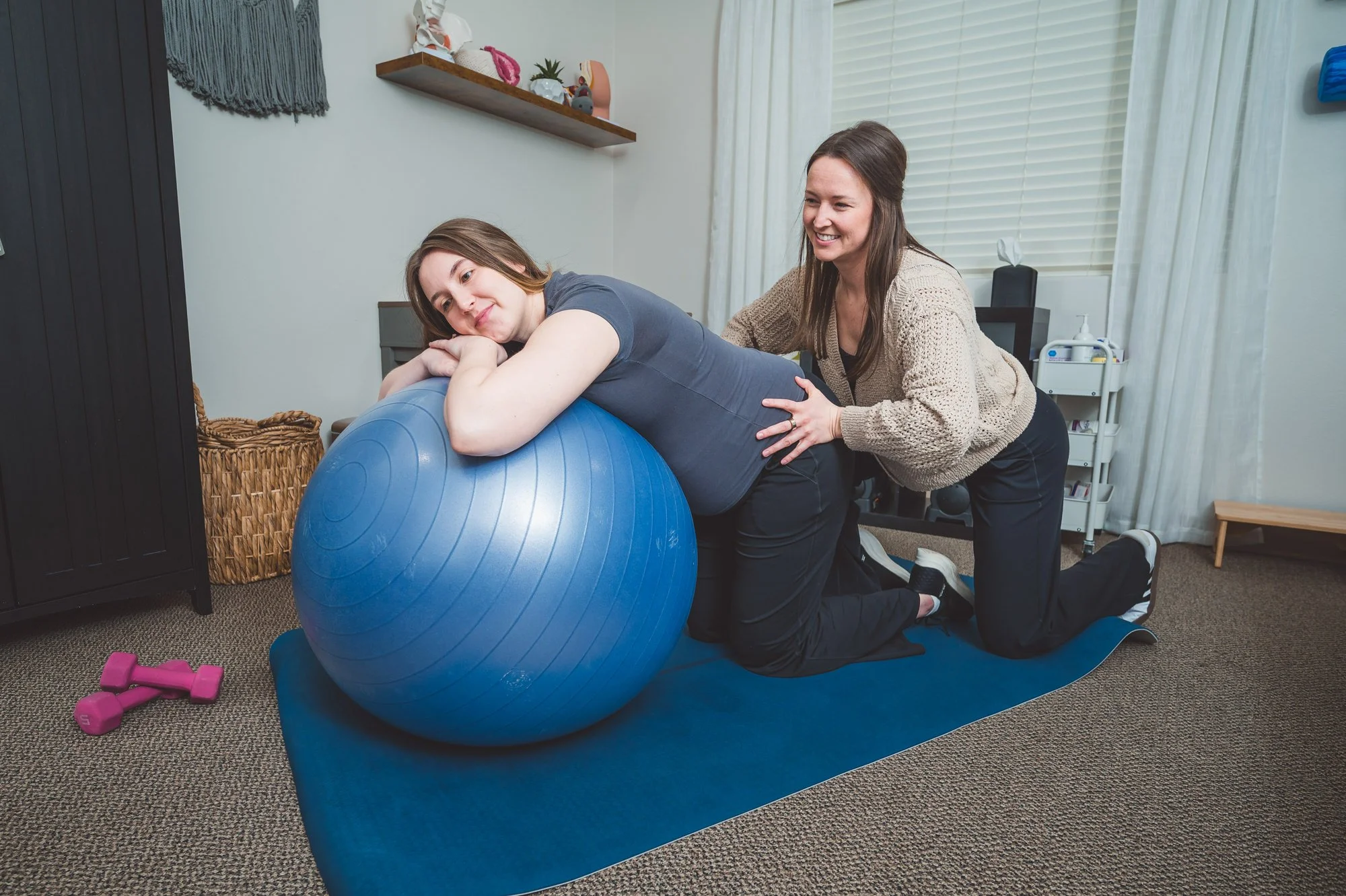 pelvic therapist helping patient with birth prep exercises in pelvic pt session
