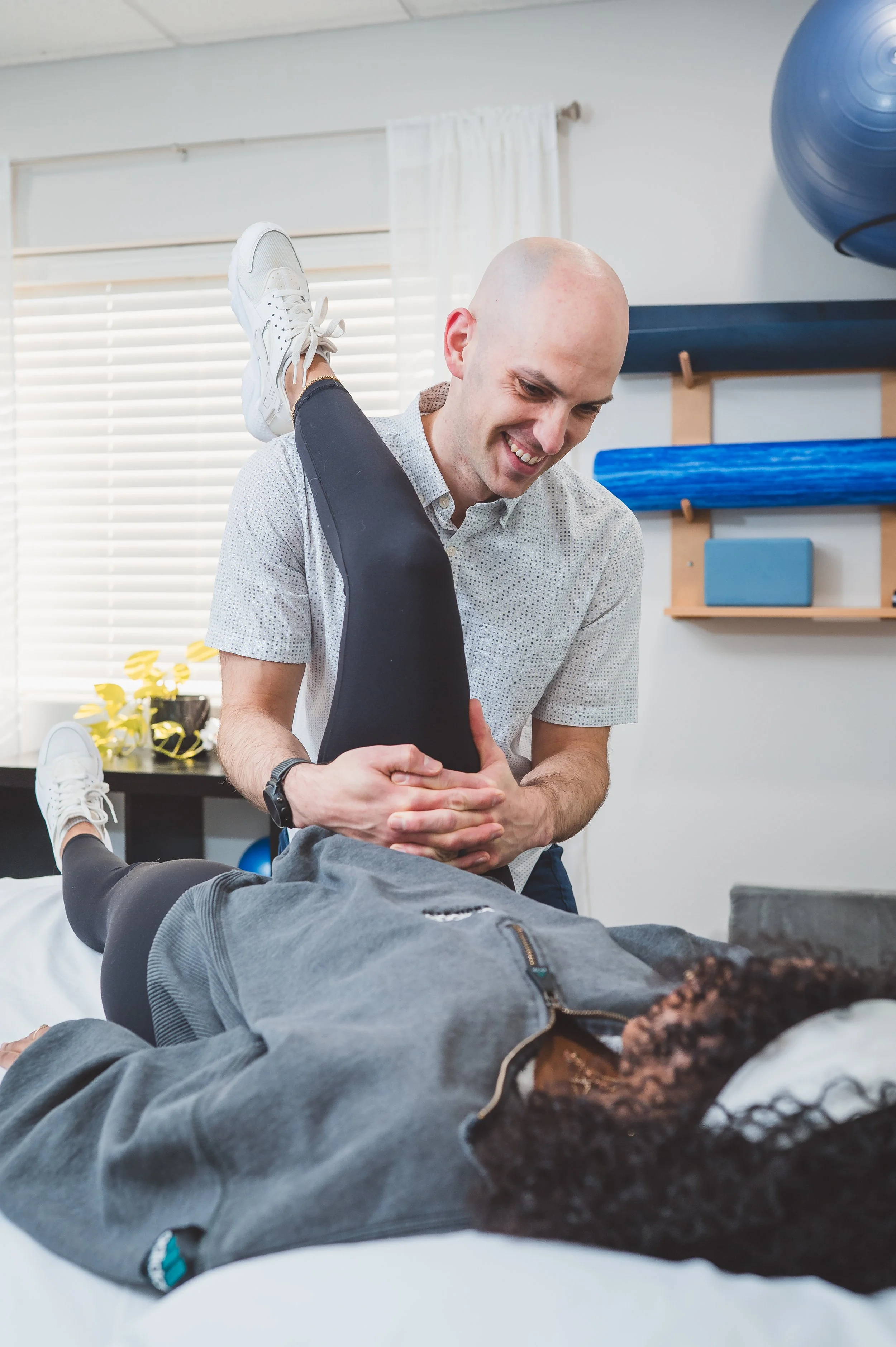 physical therapist performing a hamstring stretch during a PT session