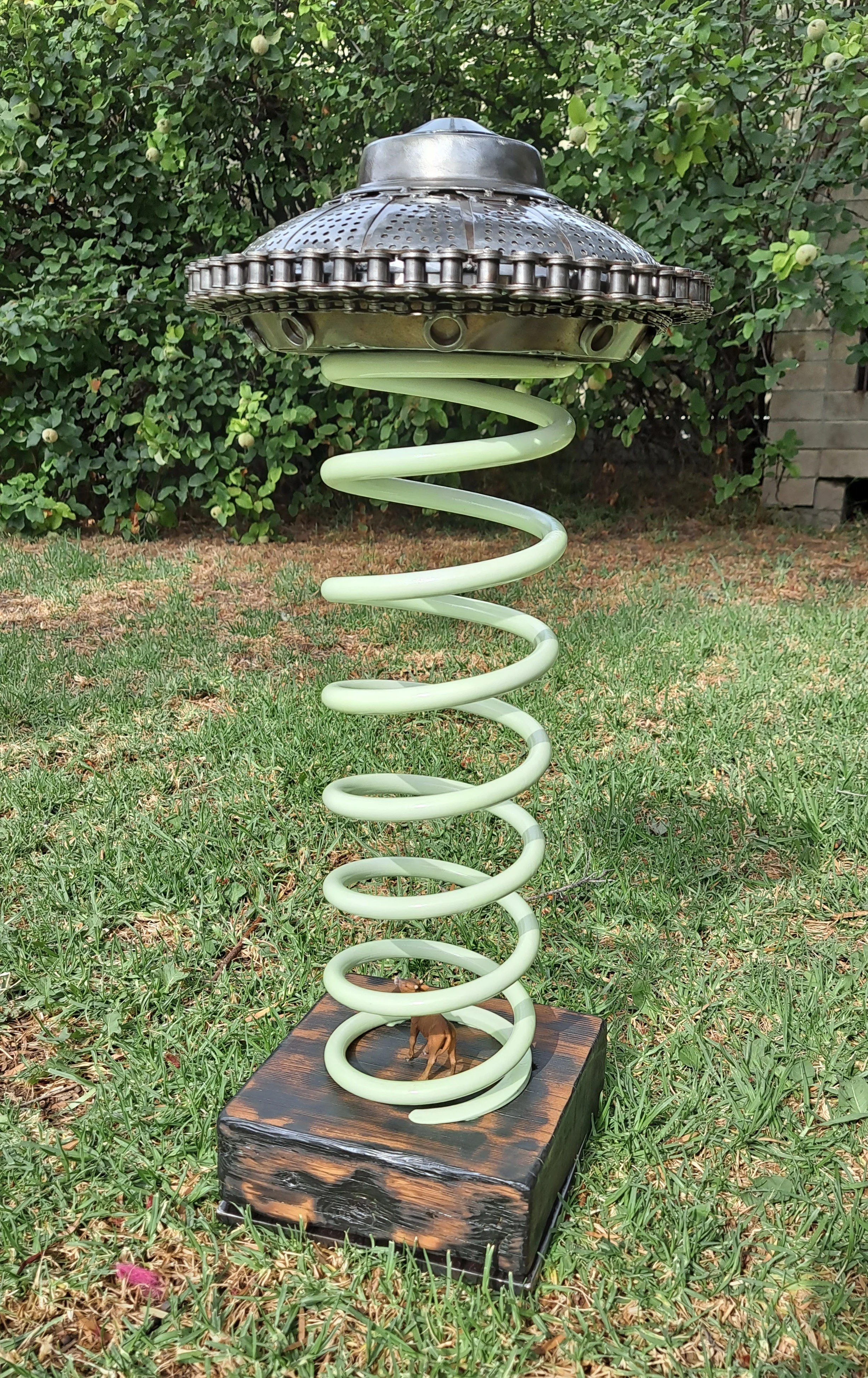 scrap metal flying saucer abducting a cow