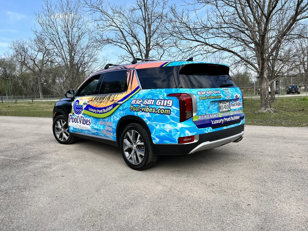 SUV with pool company advertisement parked in an outdoor area