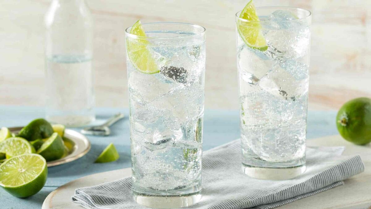 Hard seltzers in a tall glass with ice and lime