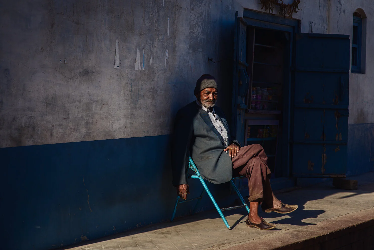 MAN-SITTING-HALF-BLUE-WALL.jpg