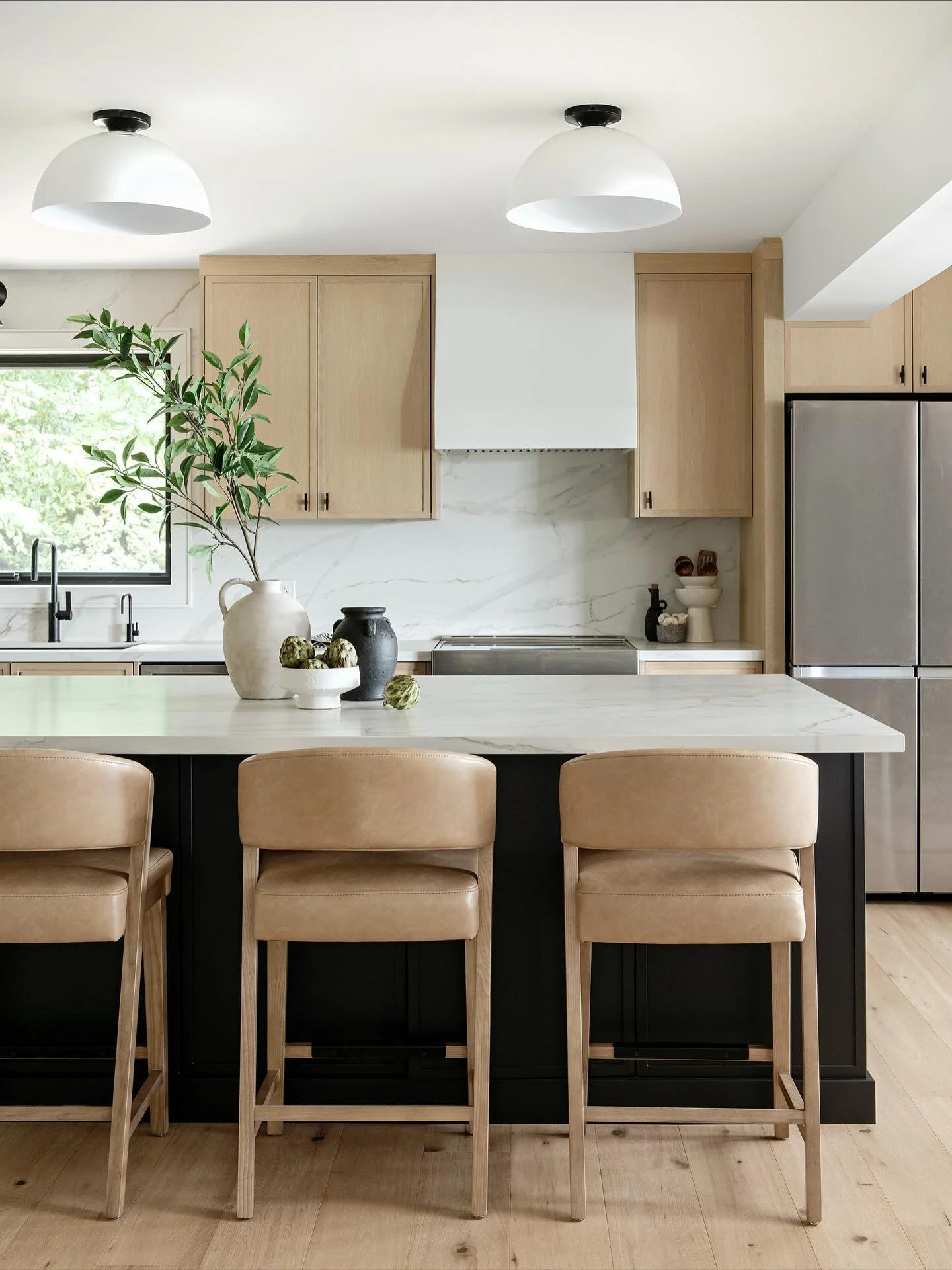 Introducing: the heart of the home.
We went with warm wood cabinetry, soft whites to keep things airy, and touches of black for depth. The wide plank hardwood floors tie it all together with the perfect organic texture. So in love with how it turned 