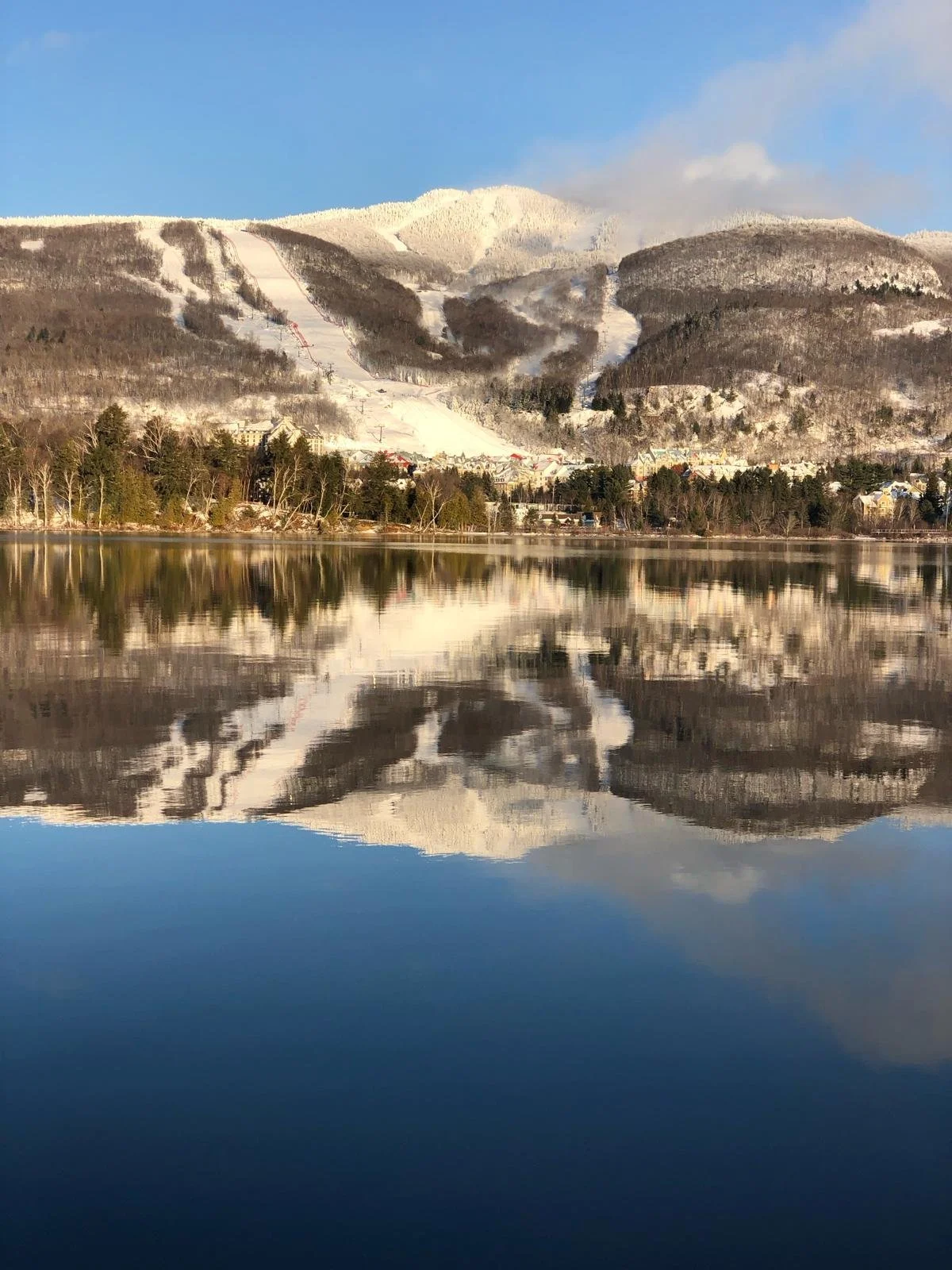 Mont-Tremblant ski resort winter training facility with scenic lake reflection and mountain ski runs