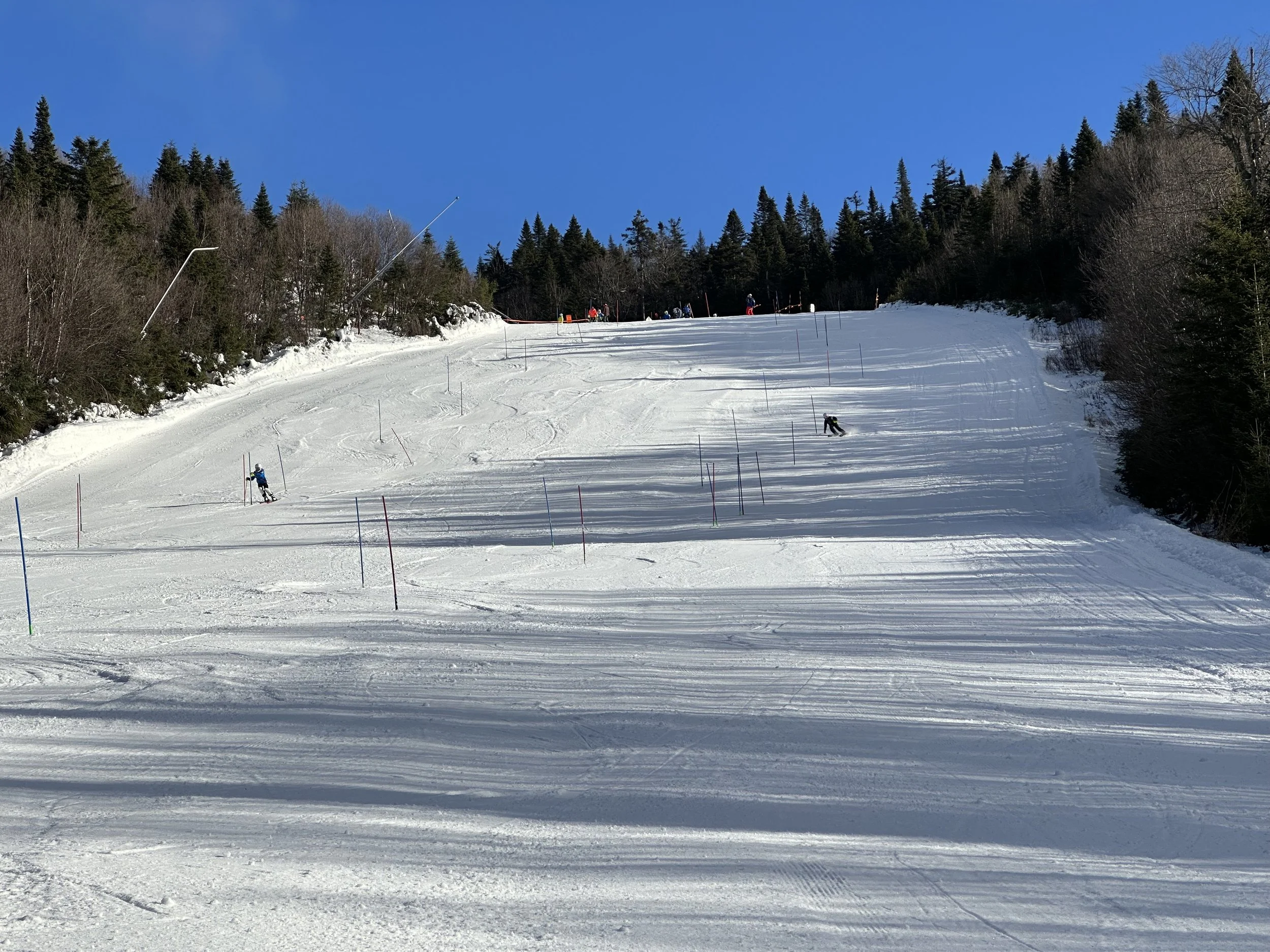 Pratte International ski camp athlete racing through slalom course in heavy snowfall at Tremblant Quebec