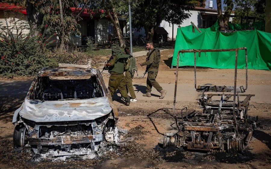 IDF troops walk through Kibbutz Nahal Oz, near the Gaza border, on October 20, 2023, following the October 7 Hamas onslaught.